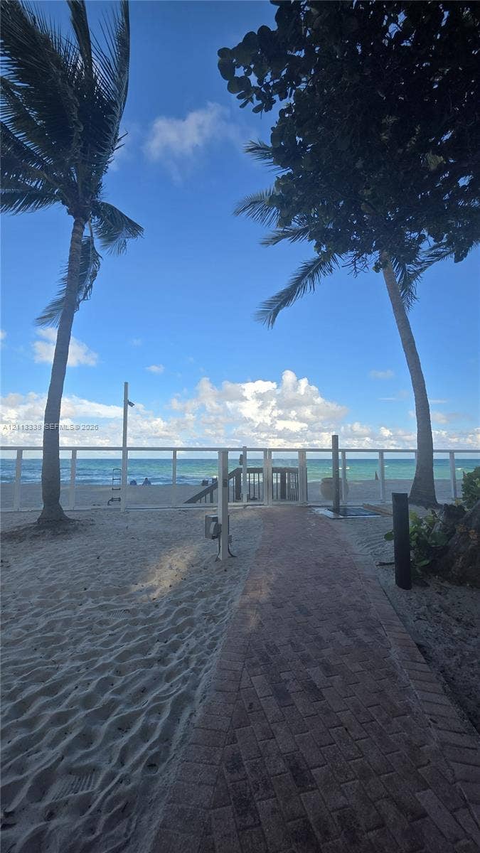 3001 S Ocean Drive, #1539, Hollywood, Hollywood, FL 33019 Brick paver pathway leading to a gated entry point with direct beach access, accented by mature palm trees