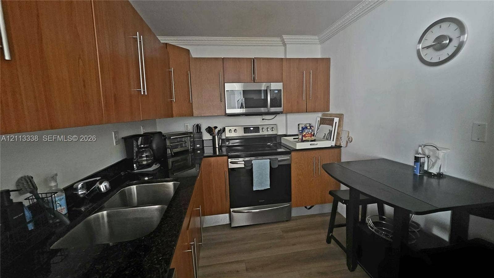 3001 S Ocean Drive, #1539, Hollywood, Hollywood, FL 33019 Kitchen featuring wood-finish cabinetry, dark stone countertops, stainless steel appliances, dual-basin sink, and light-toned wood-finish flooring