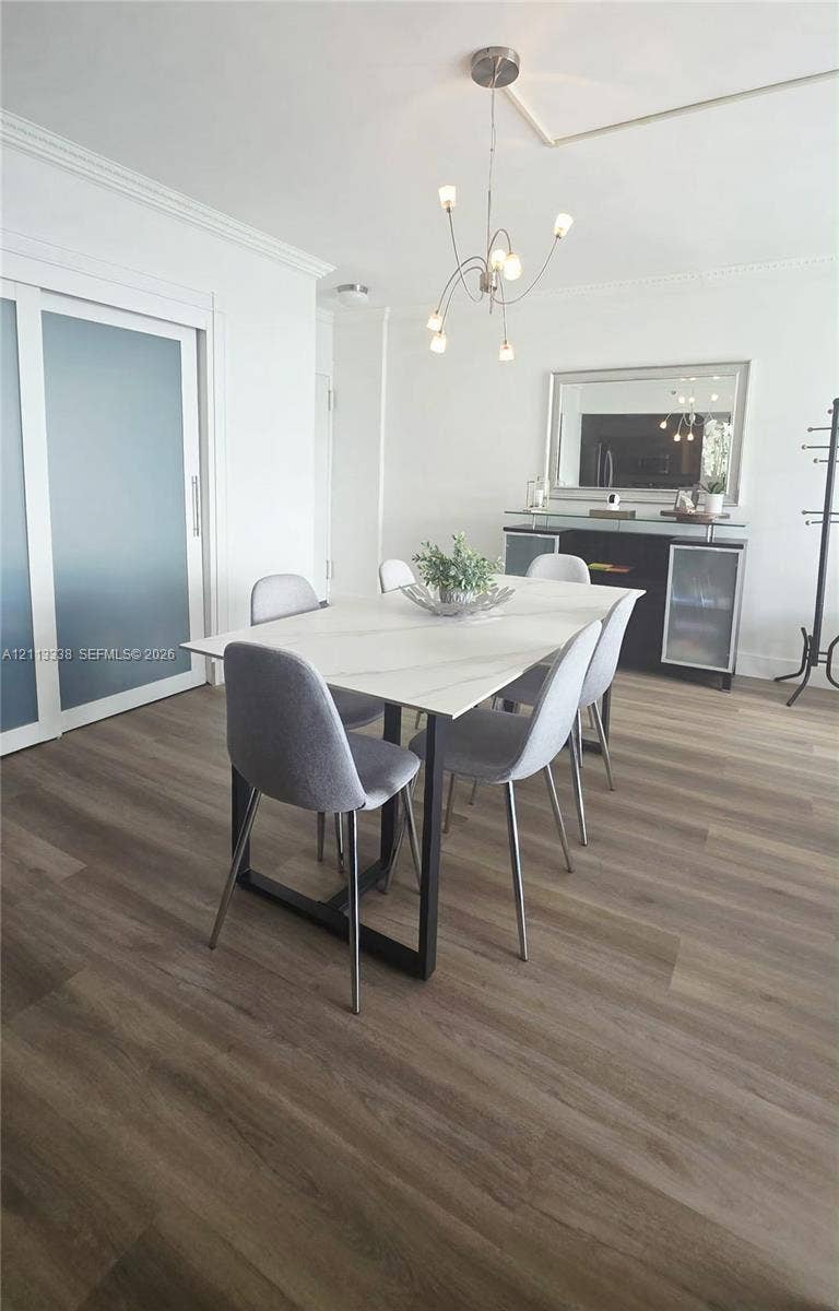3001 S Ocean Drive, #1539, Hollywood, Hollywood, FL 33019 Wood-finish flooring, sliding opaque glass door, crown molding, and modern multi-arm chandelier