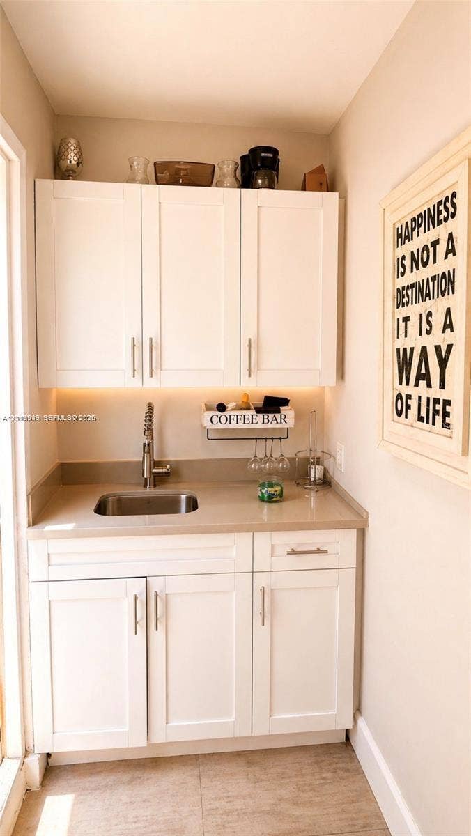 2425 SW 21st Terrace, #1, Miami, Miami, FL 33145 Built-in white cabinetry featuring shaker-style doors, matte-finish countertop, integrated stainless steel sink, gooseneck faucet, and under-cabinet lighting