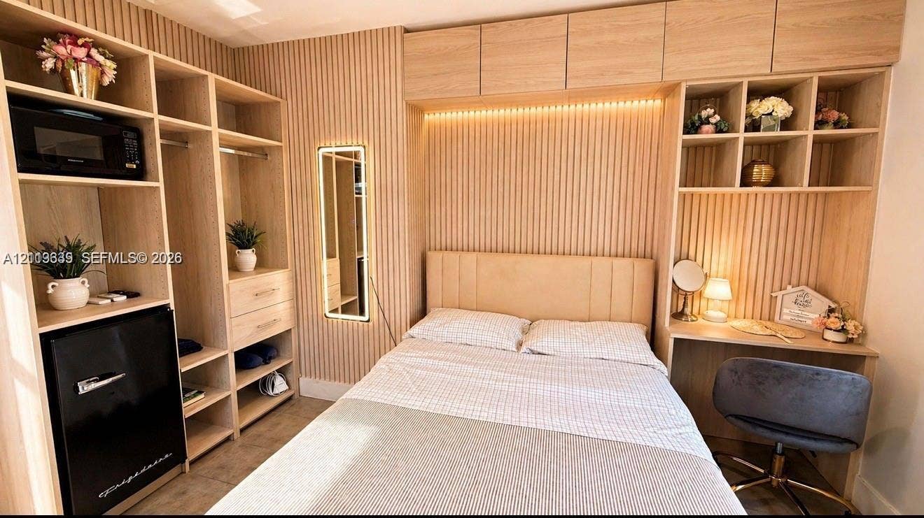 2425 SW 21st Terrace, #1, Miami, Miami, FL 33145 Custom light-toned wood-finish built-in cabinetry featuring open shelving, integrated desk, and vertical slat accent wall paneling with recessed ambient lighting