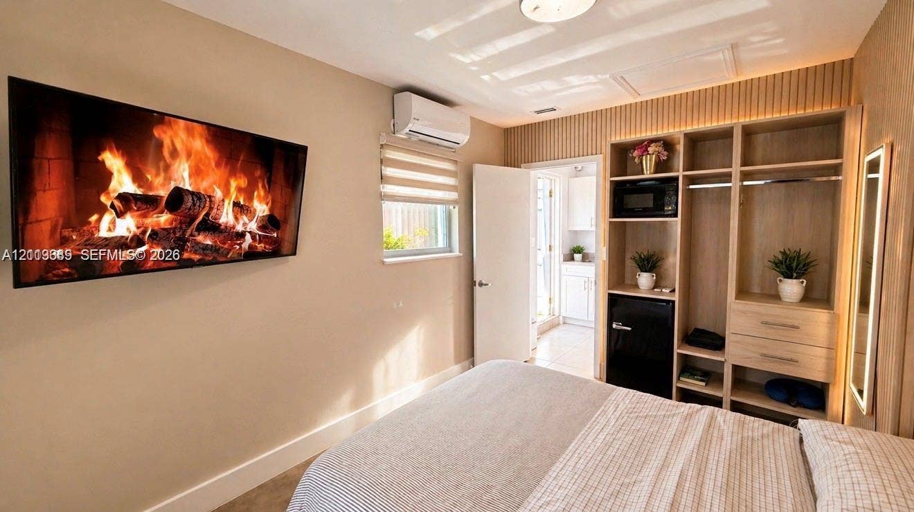 2425 SW 21st Terrace, #1, Miami, Miami, FL 33145 Custom built-in wood cabinetry with integrated shelving and drawer storage, vertical wood-slat accent wall, wall-mounted ductless air conditioning unit, and flush-mount ceiling lighting