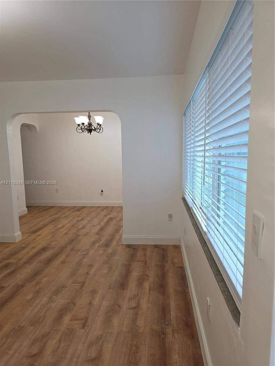 7207 Bay Drive, #2, Miami Beach, Miami Beach, FL 33141 Arched doorway, multi-light hanging chandelier, and windows fitted with horizontal blinds