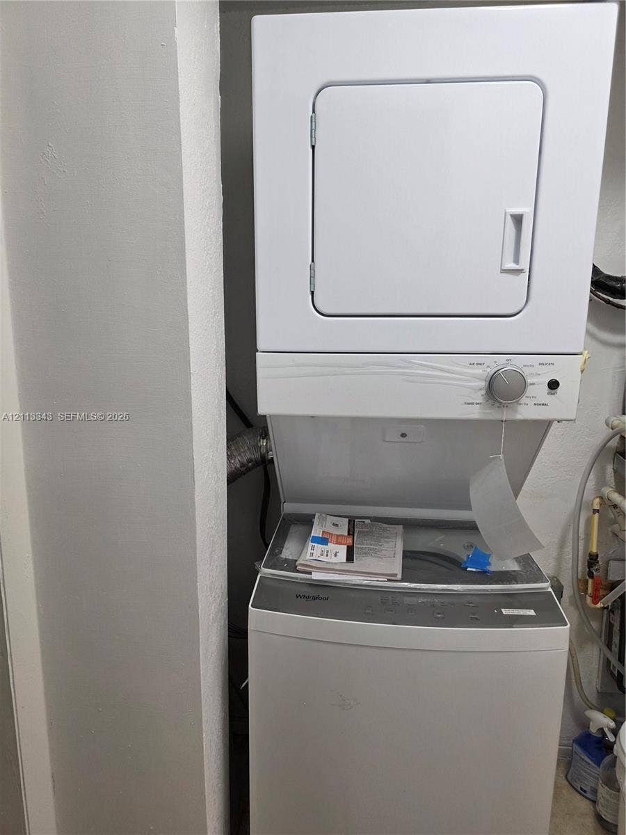 7207 Bay Drive, #2, Miami Beach, Miami Beach, FL 33141 Stacked Whirlpool laundry center featuring a top-loading washer and front-loading dryer