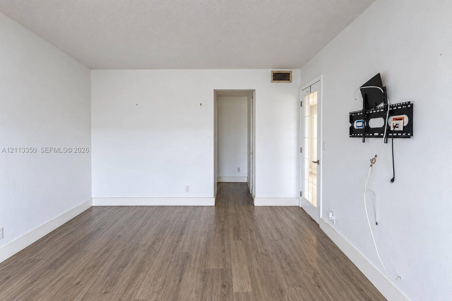 Wood-finish flooring, neutral wall palette, and glass-paneled exterior door