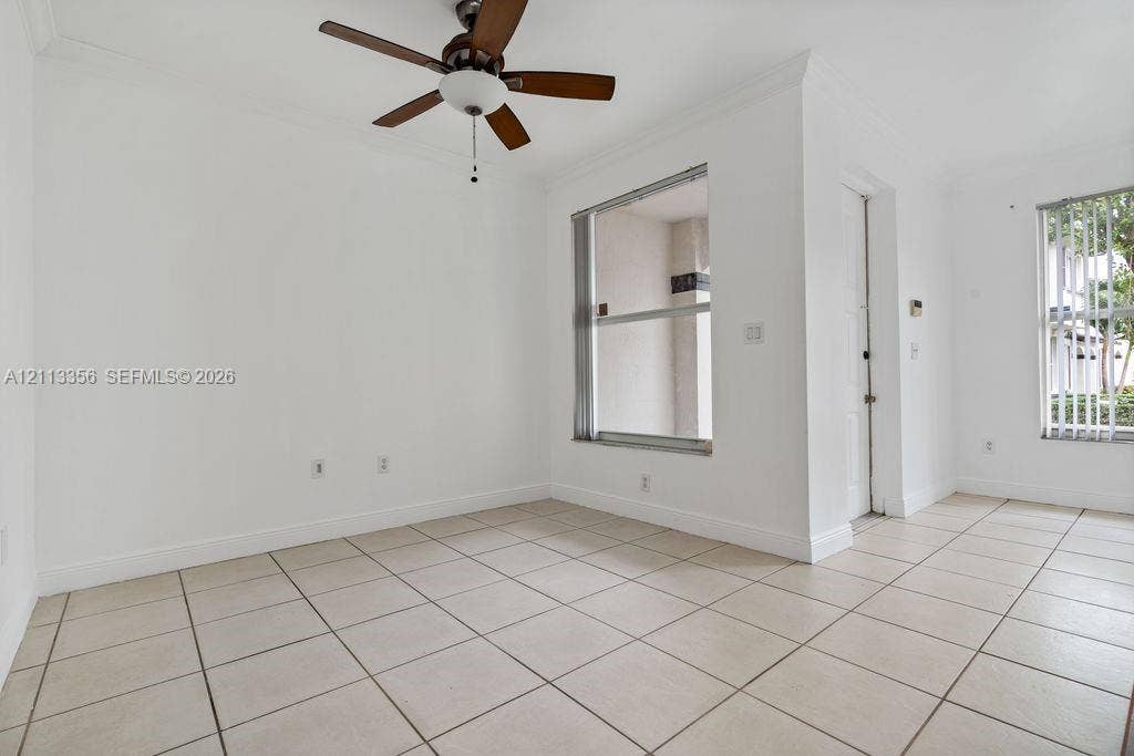 8715 SW 152nd Avenue, #312, Miami, Miami, FL 33193 Neutral-toned ceramic tile flooring, ceiling fan with integrated lighting, and multiple windows with vertical blinds
