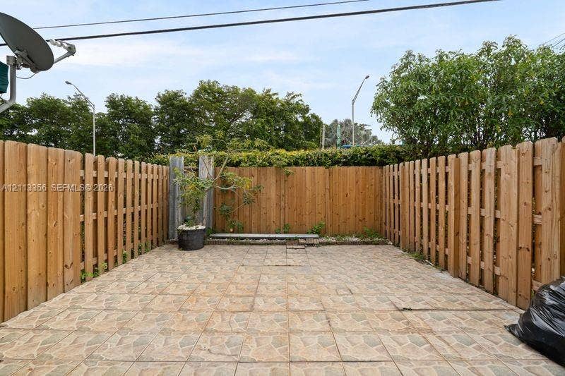 8715 SW 152nd Avenue, #312, Miami, Miami, FL 33193 Enclosed courtyard featuring stone-finish paver flooring and full-height wood-slat perimeter fencing