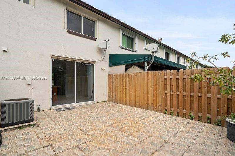 8715 SW 152nd Avenue, #312, Miami, Miami, FL 33193 Private patio featuring stone-tiled hardscaping and a wood privacy fence