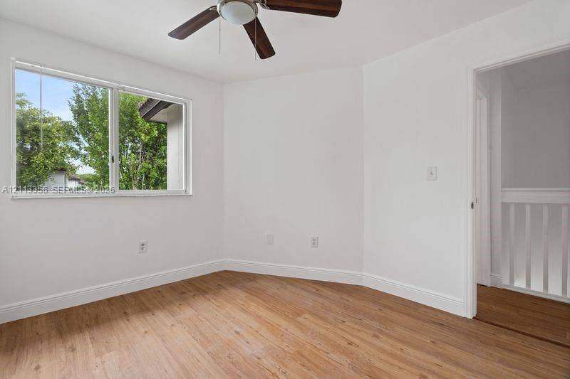 8715 SW 152nd Avenue, #312, Miami, Miami, FL 33193 Room featuring wood-finish flooring, a ceiling fan with integrated lighting, and a window with horizontal blinds
