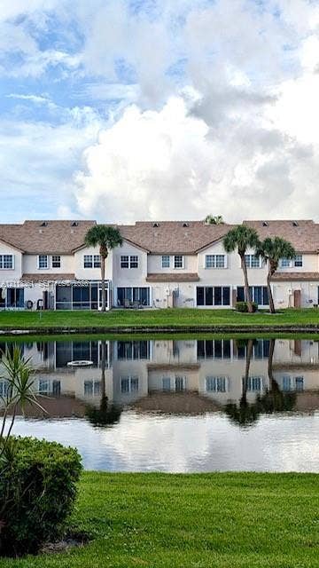 9395 Boca River Circle, Boca Raton, Boca Raton, FL 33434 Large-format gloss tile flooring featuring veining throughout, complemented by expansive floor-to-ceiling sliding glass doors and recessed ceiling lighting