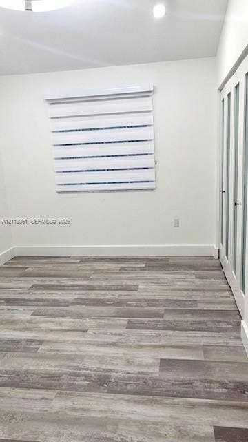 9395 Boca River Circle, Boca Raton, Boca Raton, FL 33434 Room featuring wood-finish flooring, recessed lighting, a modern circular ceiling fixture, and dual-layer adjustable roller shades