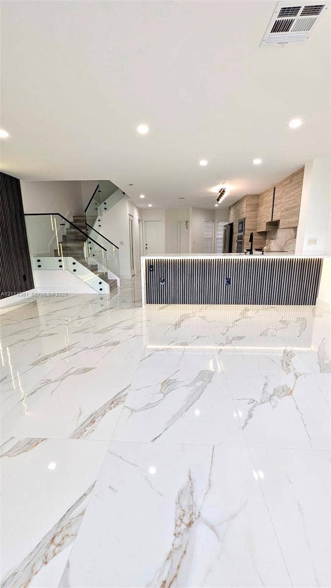 9395 Boca River Circle, Boca Raton, Boca Raton, FL 33434 Kitchen featuring two-tone cabinetry, stone-finish countertops, full-height backsplash, stainless steel built-in appliances, and large-format tile flooring
