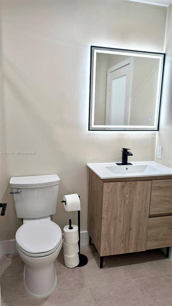 9395 Boca River Circle, Boca Raton, Boca Raton, FL 33434 Walk-in shower featuring a sliding glass enclosure with matte black hardware, herringbone-patterned wall tile, pebble-style floor tiling, and a rainfall showerhead