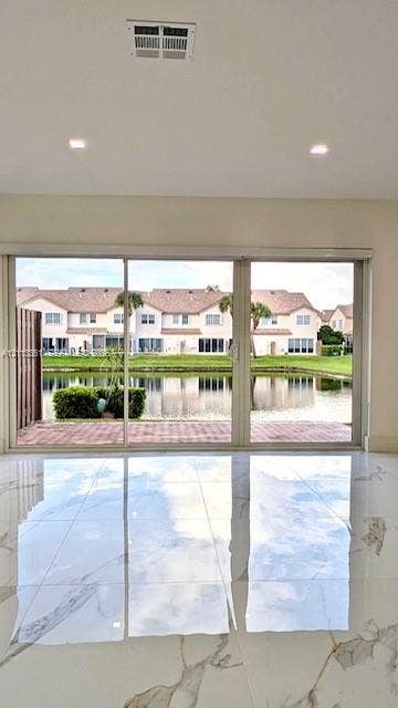 9395 Boca River Circle, Boca Raton, Boca Raton, FL 33434 Floating vanity with wood-finish drawer, matte black hardware, stone-surface countertop, integrated vessel sink, and rectangular LED-backlit mirror, complemented by large-format tile flooring