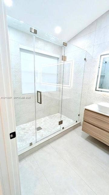 9395 Boca River Circle, Boca Raton, Boca Raton, FL 33434 Walk-in shower featuring a frameless glass enclosure, rainfall showerhead with a handheld sprayer, wall-integrated niche, and wood-finish floating vanity with a vessel sink