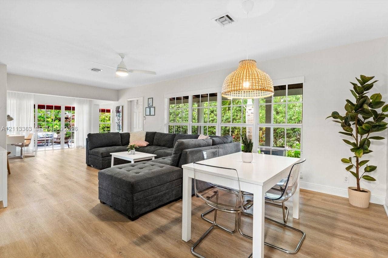 617 NE 9th Avenue, #72, Fort Lauderdale, Fort Lauderdale, FL 33304 Open-concept space featuring wood-finish flooring, multi-pane windows, a woven dome pendant light, and sliding glass doors