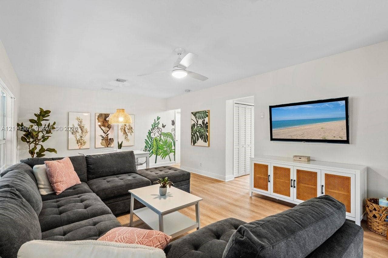 617 NE 9th Avenue, #72, Fort Lauderdale, Fort Lauderdale, FL 33304 Living area featuring light-toned wood-finish flooring, a white ceiling fan with integrated lighting, and a white bi-fold closet door