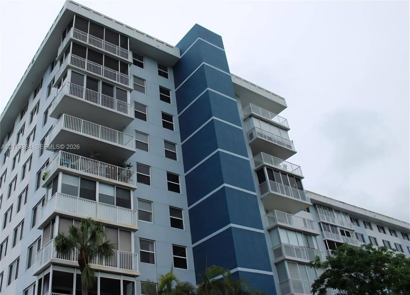 4200 Hillcrest Drive, #717, Hollywood, FL 33021 Multi-story residential building featuring a blue facade, vertical accent detailing, and private screened-in balconies