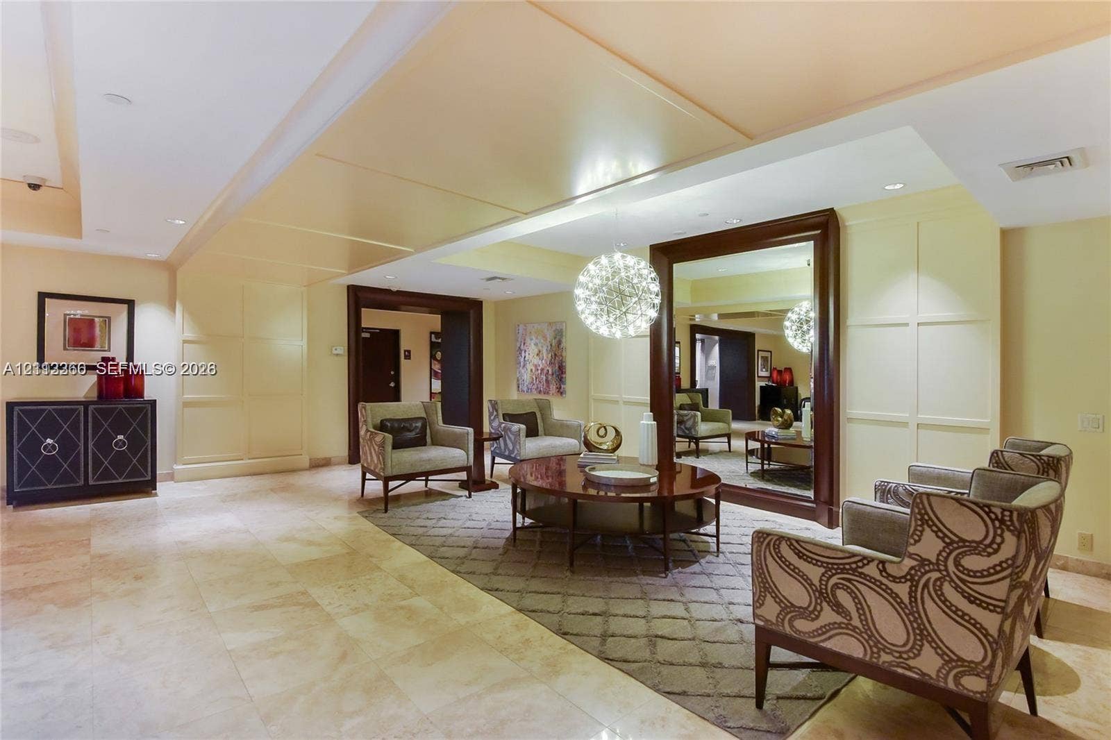 9499 Collins Avenue, #904, Surfside, FL 33154 Large-format stone flooring, recessed lighting, millwork paneling, and a floor-to-ceiling framed mirror