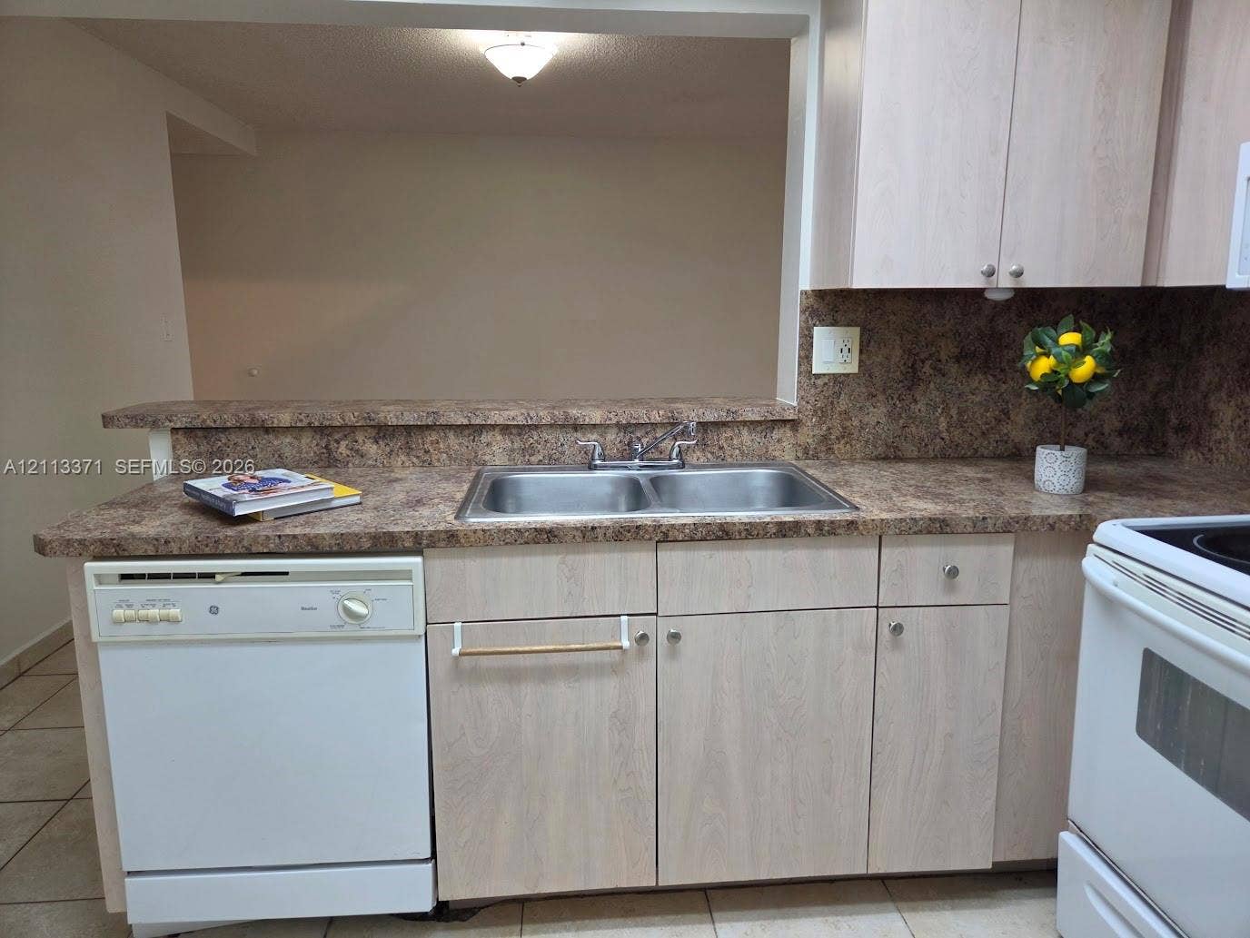 9439 Fontainebleau Boulevard, #104, Miami, Miami, FL 33172 Kitchen featuring light-finish cabinetry, a double-basin stainless steel sink with a mounted faucet, patterned laminate countertops, and white appliances