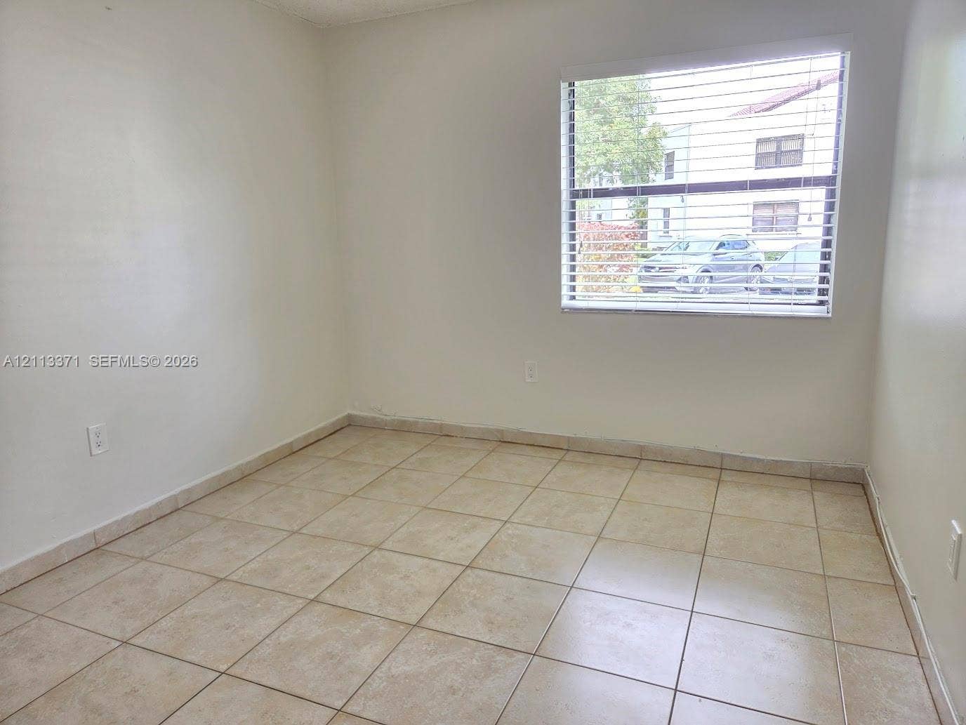 9439 Fontainebleau Boulevard, #104, Miami, Miami, FL 33172 Neutral-toned ceramic tile flooring, clean painted walls, and a large window featuring horizontal blinds