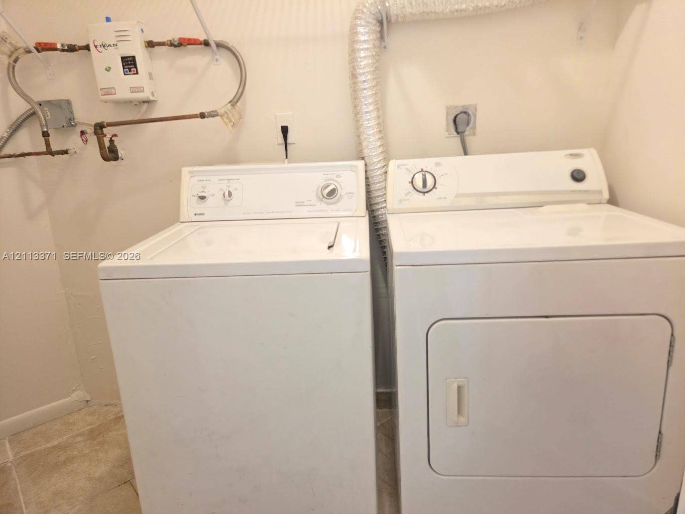 9439 Fontainebleau Boulevard, #104, Miami, Miami, FL 33172 Laundry area featuring a tankless water heater, dedicated washer and dryer hookups, and ceramic tile flooring
