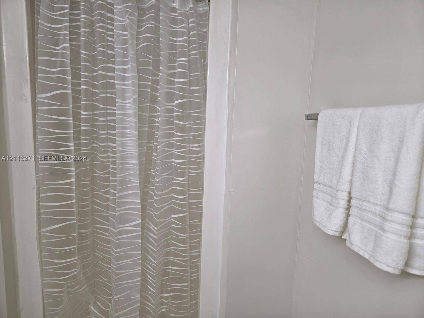 9439 Fontainebleau Boulevard, #104, Miami, Miami, FL 33172 Shower enclosure with seamless wall panels and a mounted metallic towel bar