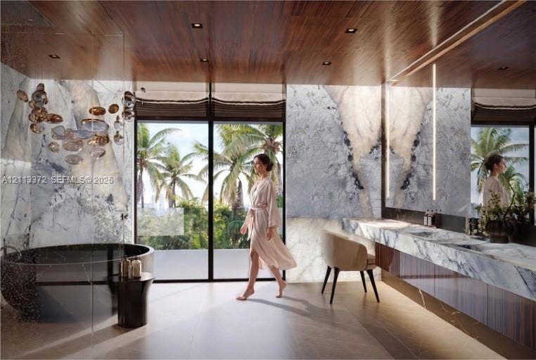 3312 NE 16th Court, Fort Lauderdale, FL 33305 Full-height stone wall cladding, floating vanity with dual integrated sinks, freestanding circular soaking tub, floor-to-ceiling glass panel windows, and wood-finish ceiling with recessed lighting