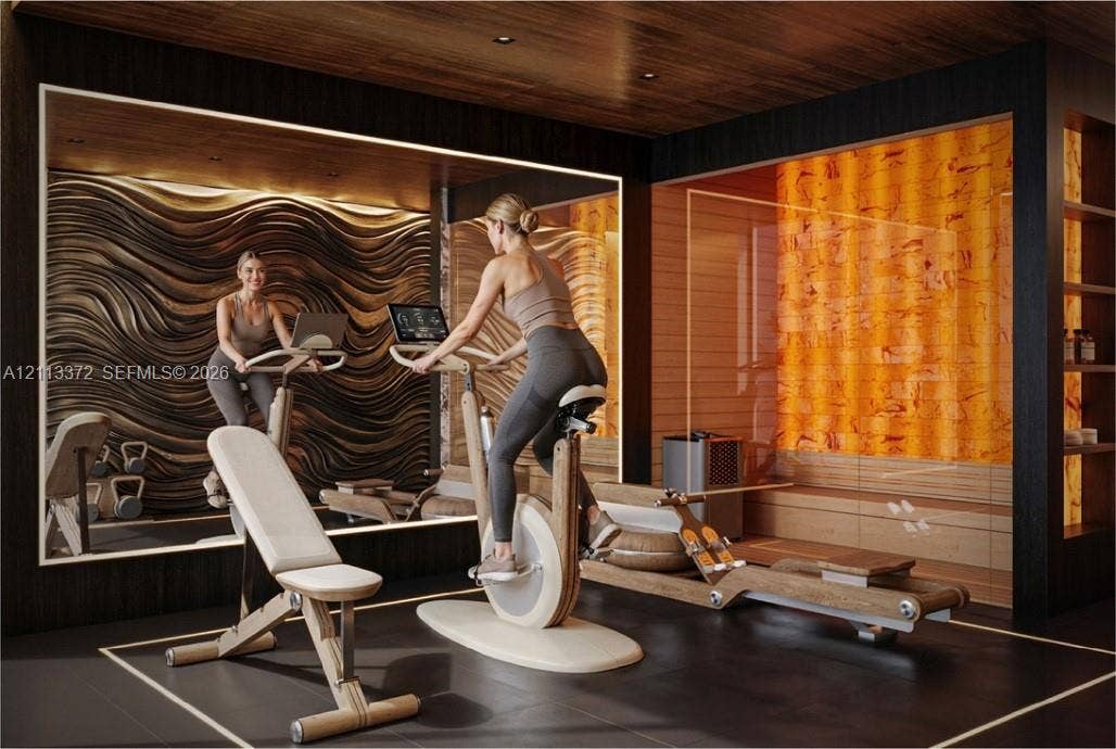 3312 NE 16th Court, Fort Lauderdale, FL 33305 Fitness room featuring a textured wave-pattern feature wall, backlit amber-toned wall panel, wood-finish ceiling, large mirror, and built-in shelving