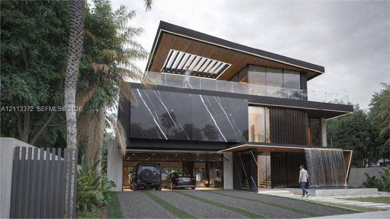 3312 NE 16th Court, Fort Lauderdale, FL 33305 Contemporary architectural exterior featuring a stone-clad facade with distinctive veining, a covered carport, an integrated water feature, and a glass-railed upper-level terrace with a wood-finished soffit