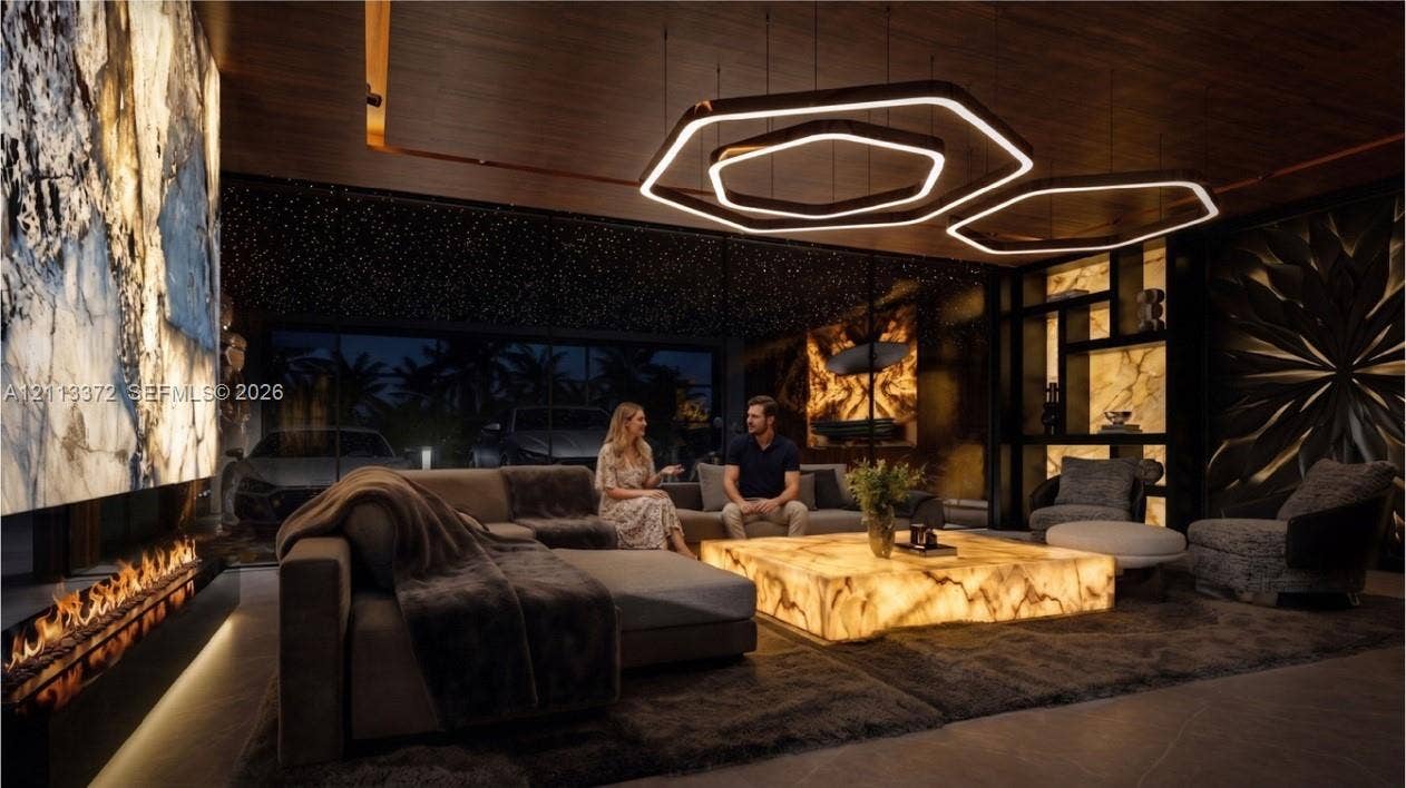 3312 NE 16th Court, Fort Lauderdale, FL 33305 Expansive interior space featuring a floor-to-ceiling backlit stone wall, modern linear fireplace, hexagonal LED pendant lighting, and custom built-in shelving with integrated illumination
