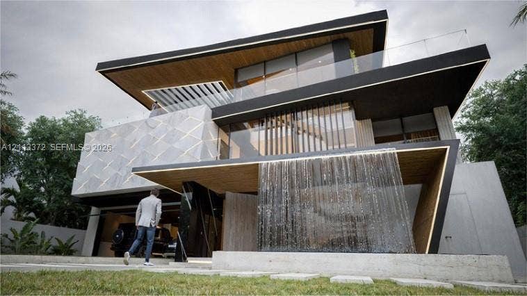 3312 NE 16th Court, Fort Lauderdale, FL 33305 Contemporary multi-level exterior featuring a cantilevered design, geometric facade tiling, wood-finish soffits, glass balcony railings, and a built-in water feature