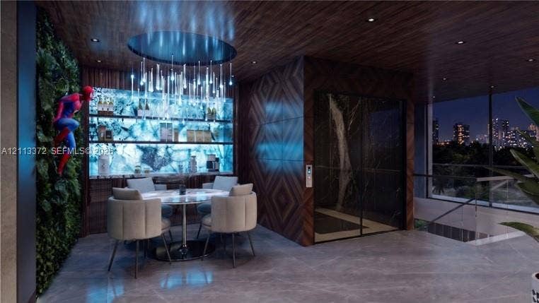 3312 NE 16th Court, Fort Lauderdale, FL 33305 Interior space featuring a backlit stone-slab bar, wood-paneled ceiling, integrated elevator with dark stone surround, and vertical botanical wall installation
