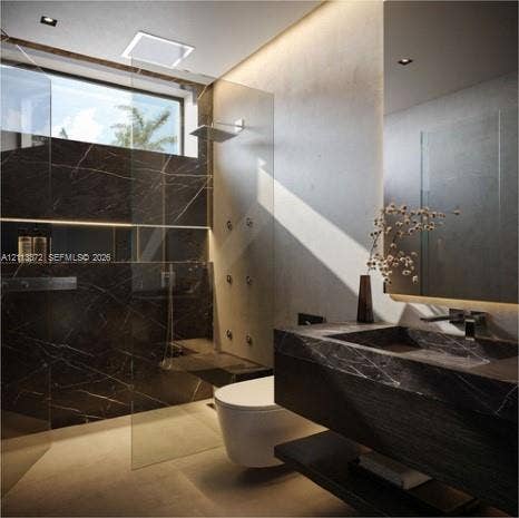 3312 NE 16th Court, Fort Lauderdale, FL 33305 Walk-in shower with stone-clad walls, glass partition, and wall-mounted shower heads