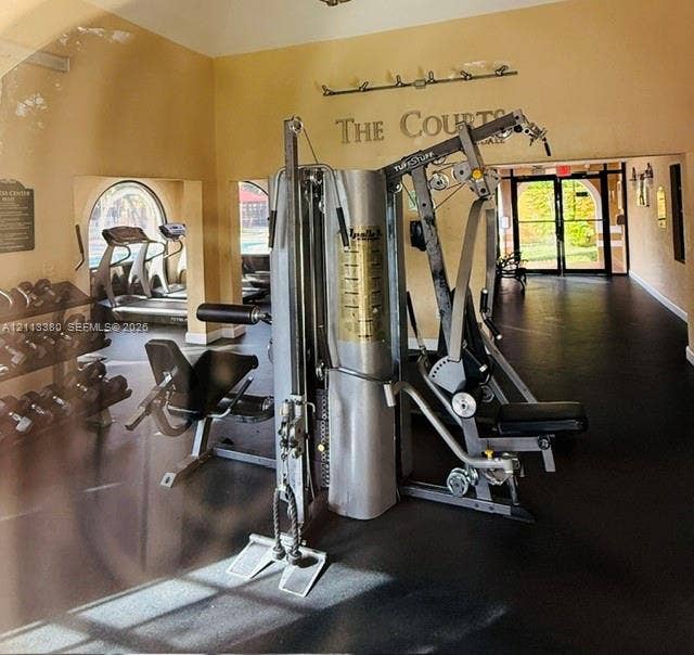 15610 SW 80th Street, #J-103, Miami, FL 33193 Fitness center featuring rubber flooring, arched windows, and mounted lighting fixtures