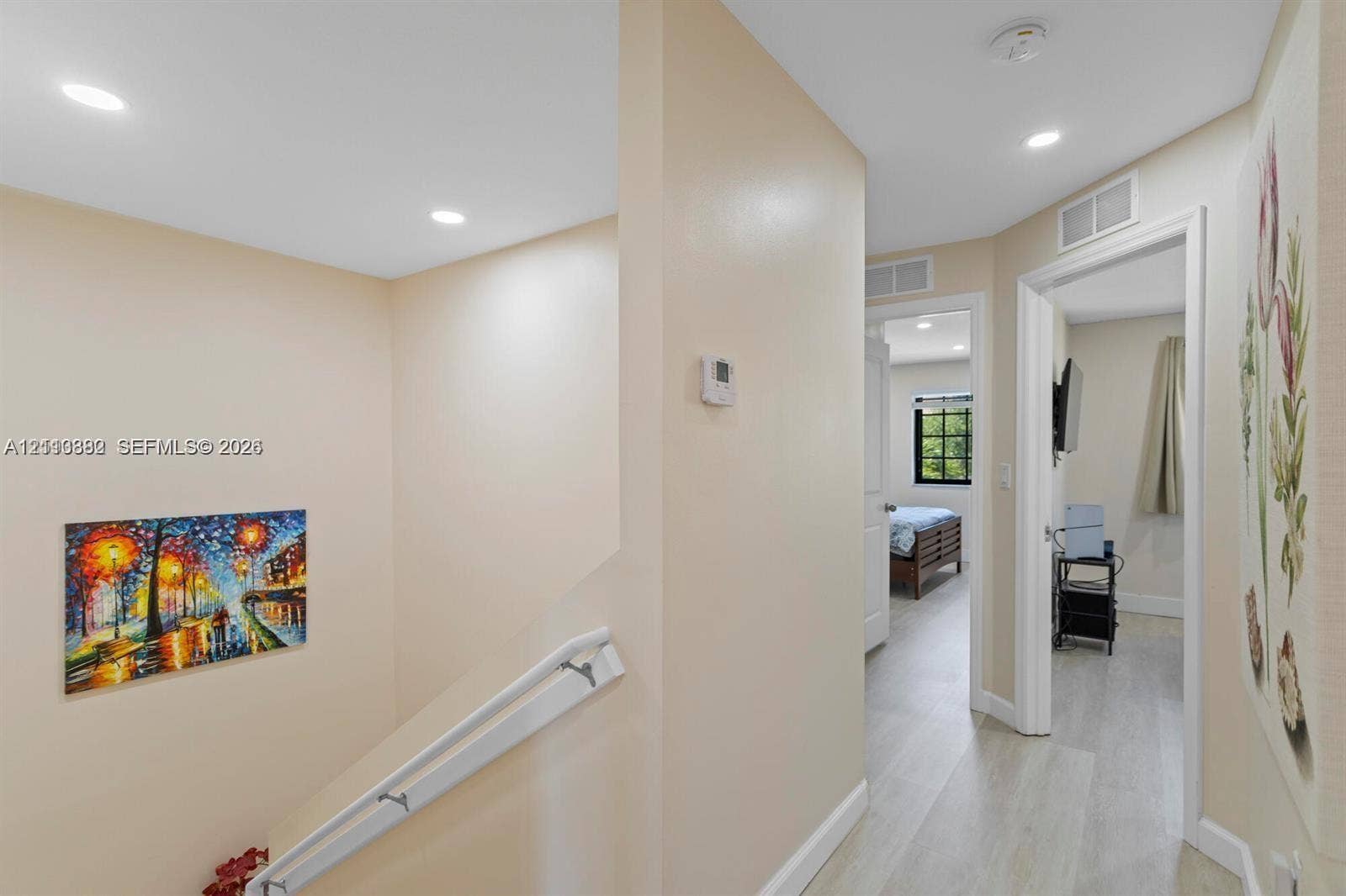 Hallway featuring wood-finish flooring, recessed lighting, and a white stair railing