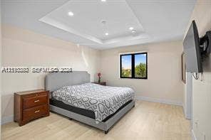 Tray ceiling featuring recessed lighting and light wood-finish flooring