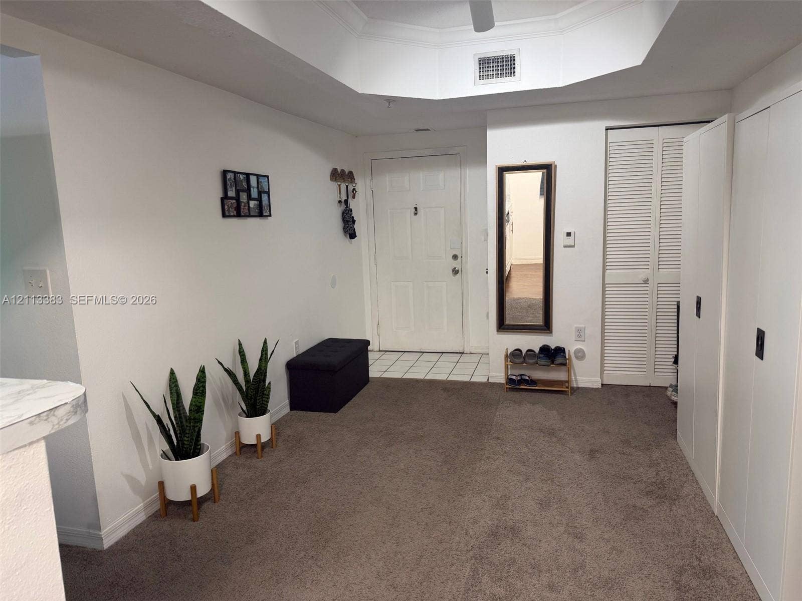 200 SW 117th Terrace, #10103, Pembroke Pines, FL 33025 Tray ceiling, tile flooring at entry, and full-height built-in closet cabinetry with louvered doors