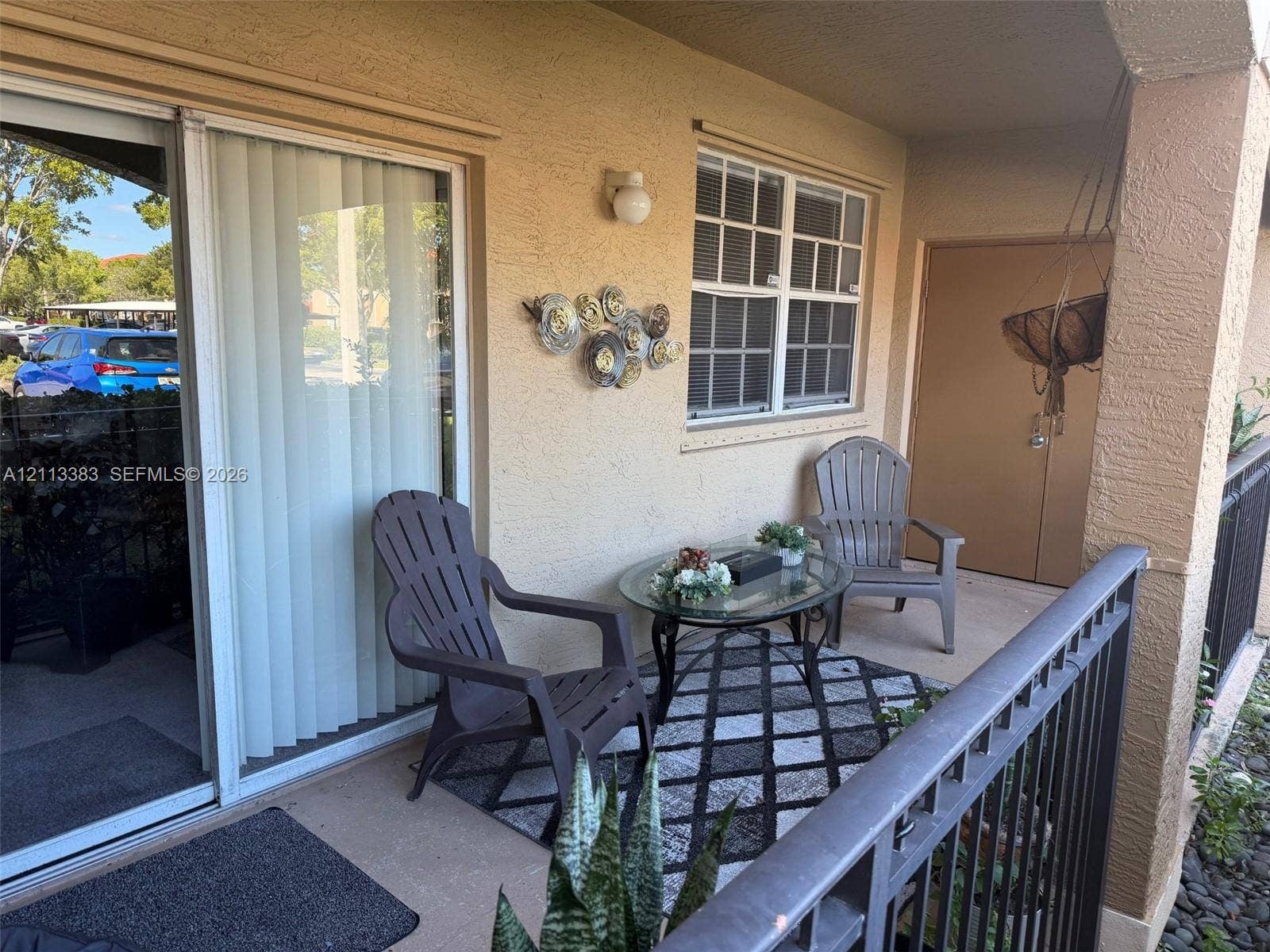 200 SW 117th Terrace, #10103, Pembroke Pines, FL 33025 Covered patio featuring concrete flooring, sliding glass door, multi-pane window, exterior wall-mounted light fixture, and metal railing