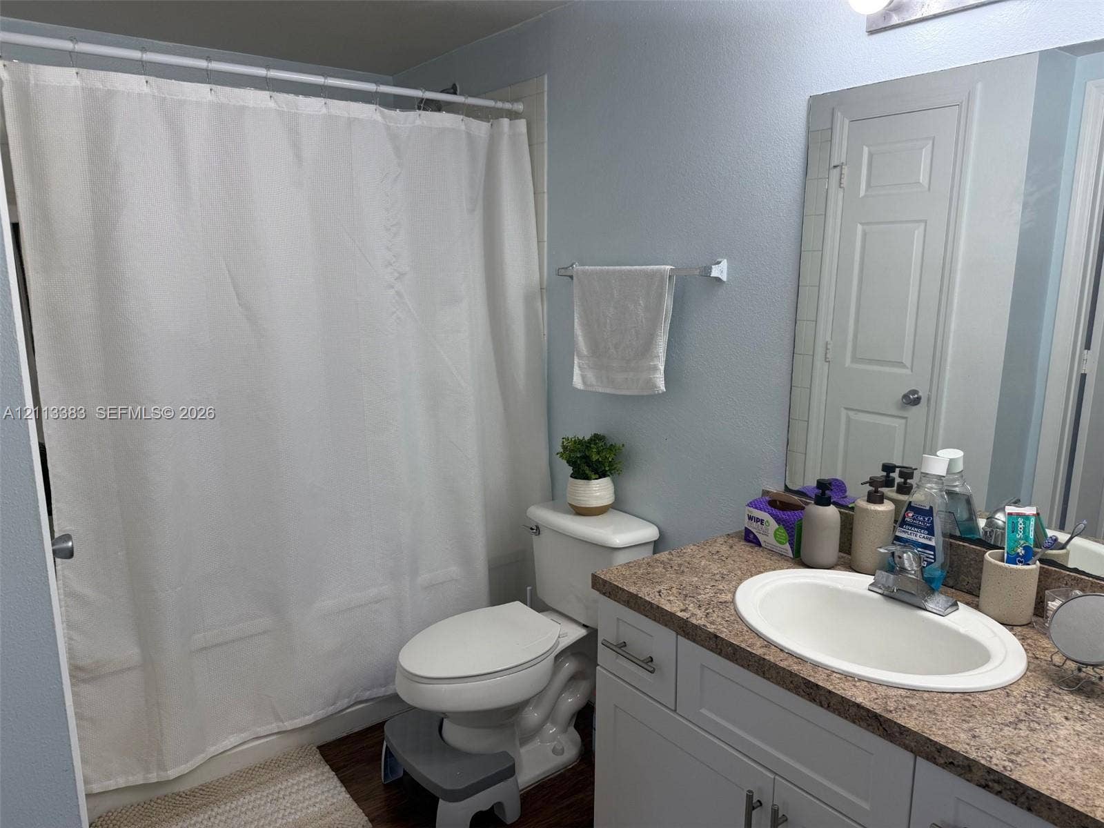 200 SW 117th Terrace, #10103, Pembroke Pines, FL 33025 Bathroom featuring a stone-pattern laminate countertop, white vanity cabinetry, integrated oval sink, chrome faucet, and a tiled tub-shower surround