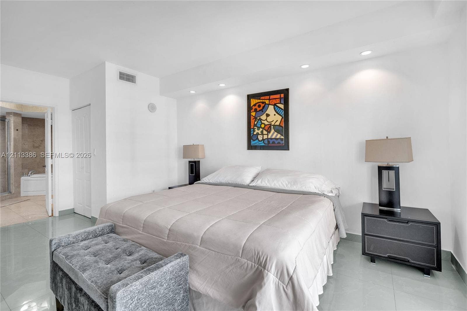 Spacious room featuring polished tile flooring, recessed ceiling lighting, and a neutral color palette