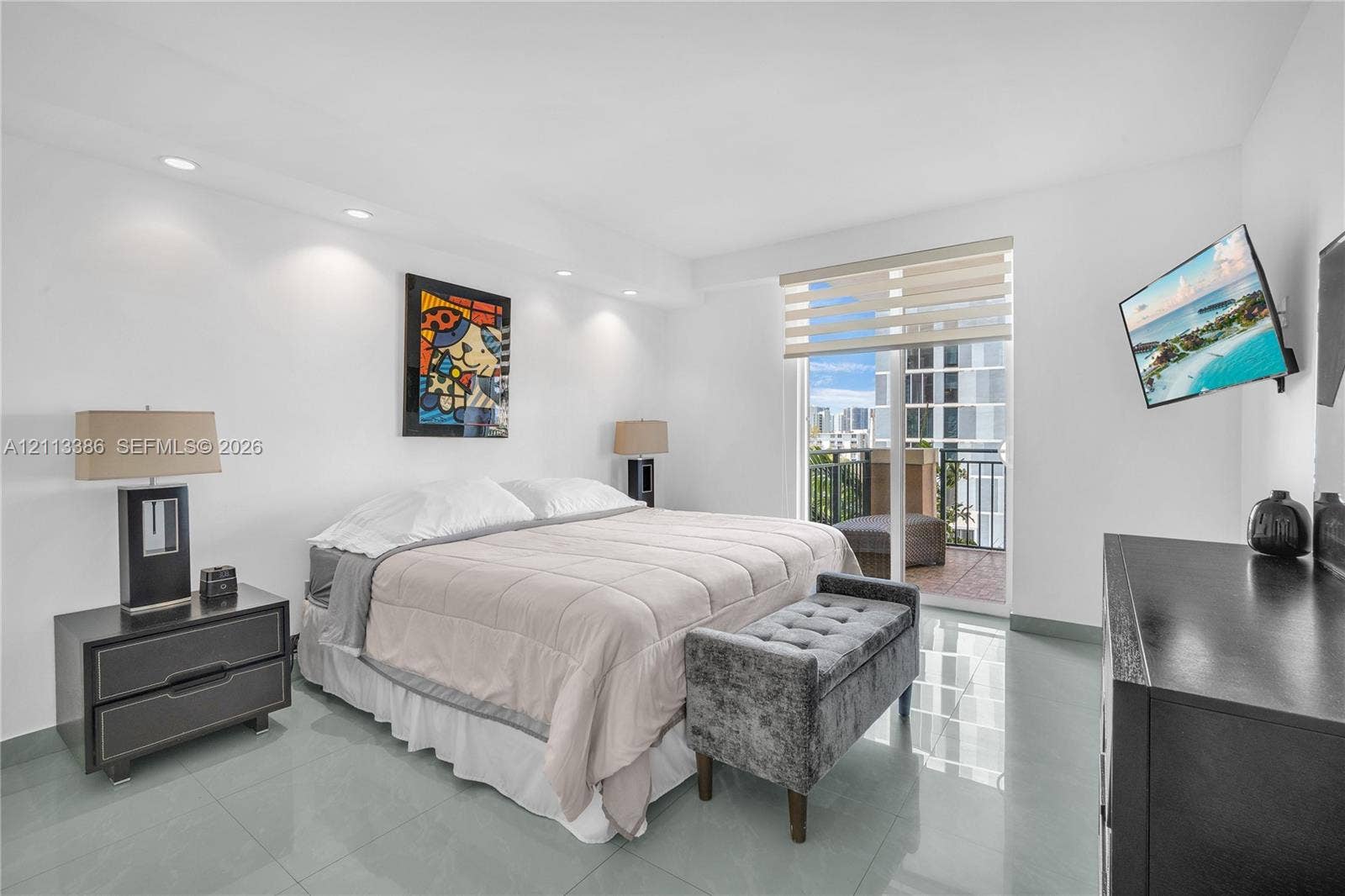 Recessed ceiling lighting, large-format tile flooring, and sliding glass door access to a private balcony