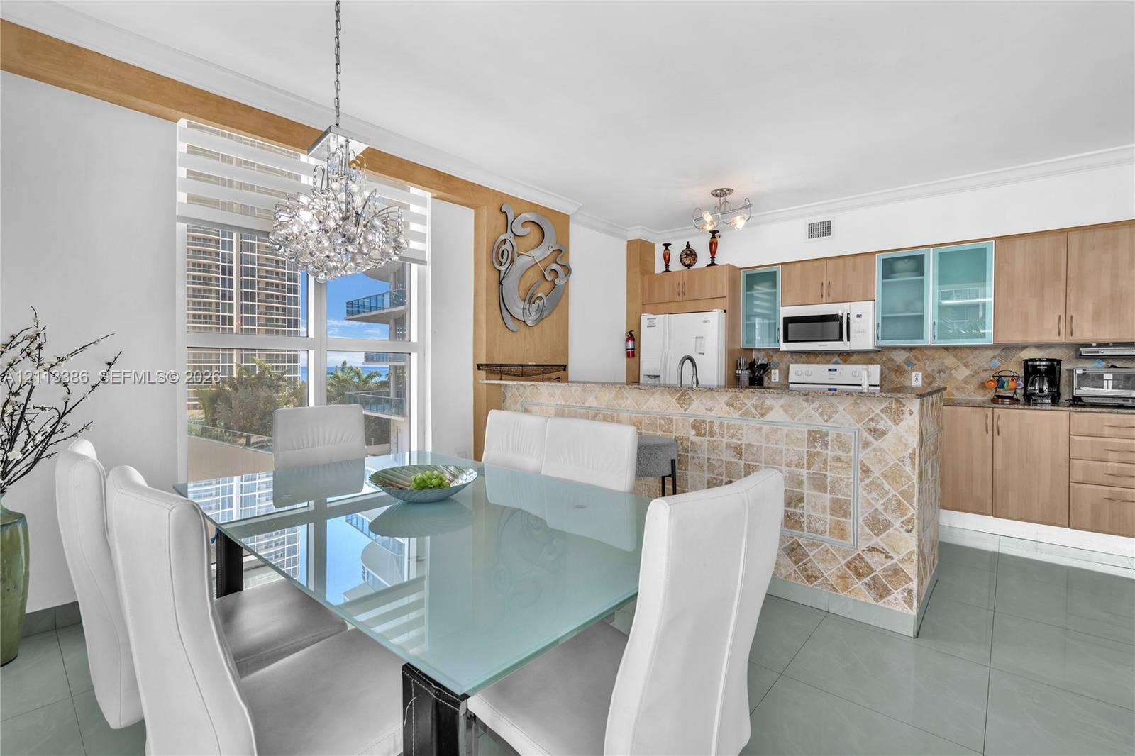 Kitchen featuring light-finish cabinetry, stone-tiled backsplash, and a stone-clad breakfast bar