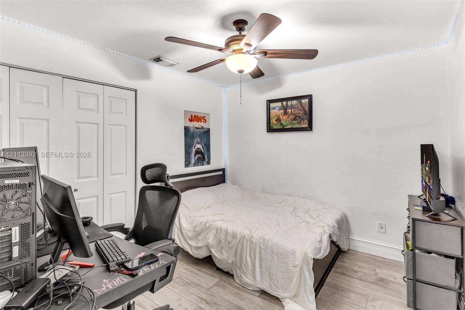 10705 SW 134th Court, Miami, FL 33186 Room featuring wood-finish flooring, ceiling fan with integrated lighting, and dual-panel closet doors