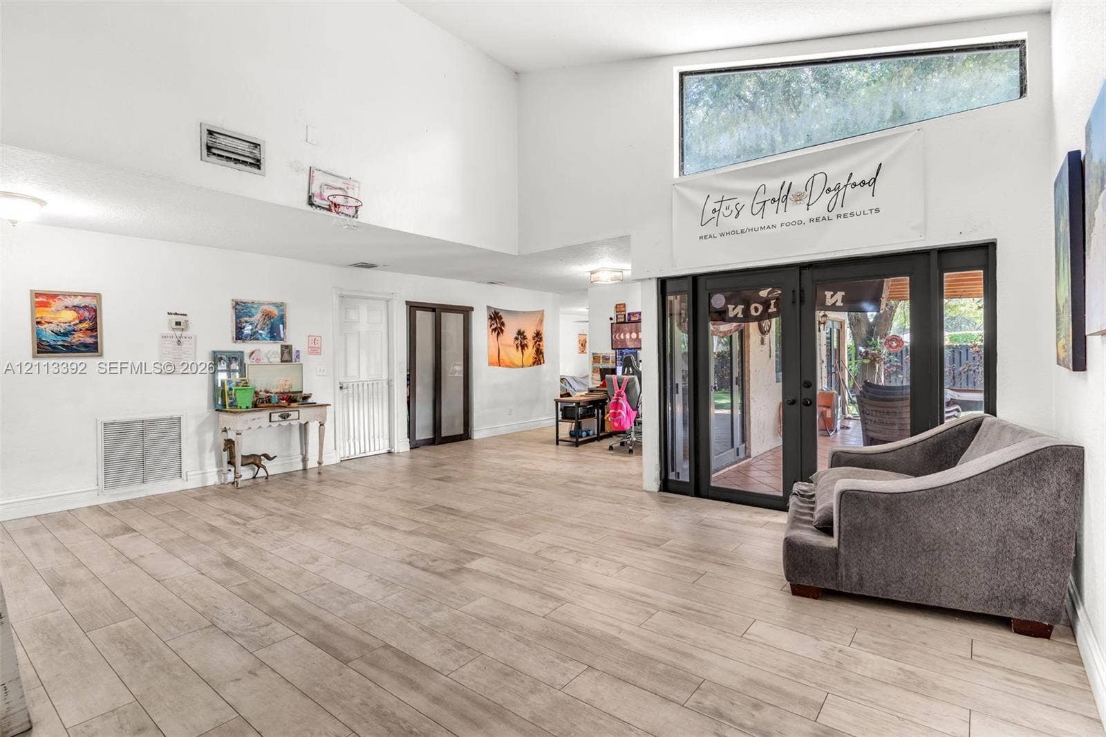 10705 SW 134th Court, Miami, FL 33186 Vaulted ceilings featuring wood-finish flooring, recessed lighting, and expansive glass-paneled double doors with a trapezoidal clerestory window