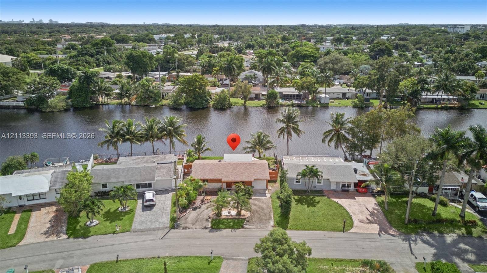 4136 SW 49th Street, Dania Beach, FL 33314 Waterfront property featuring direct water frontage, concrete bulkhead, mature palm trees, and residential street access
