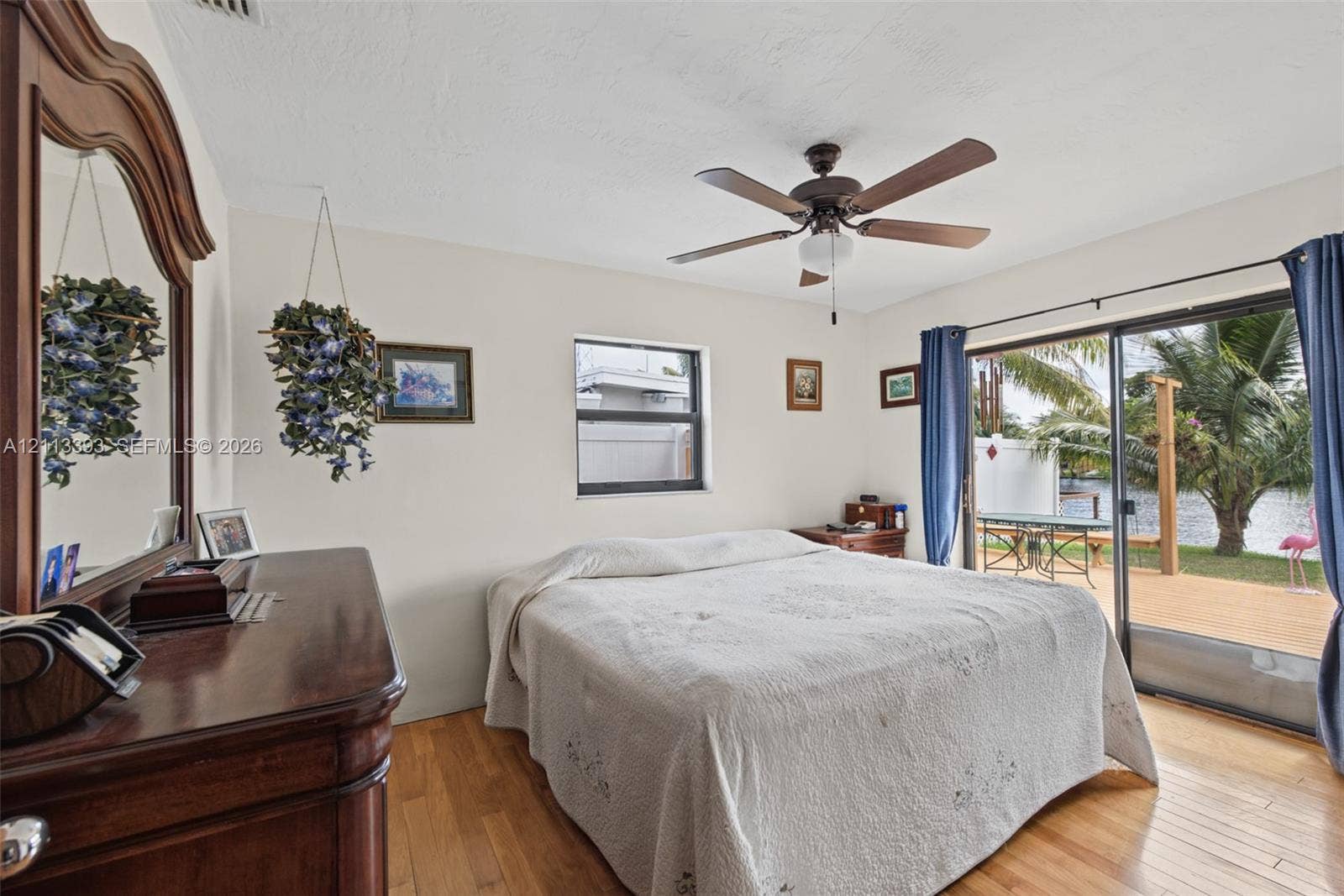 4136 SW 49th Street, Dania Beach, FL 33314 Wood-finish flooring, ceiling fan with integrated lighting, and sliding glass doors with access to an exterior deck