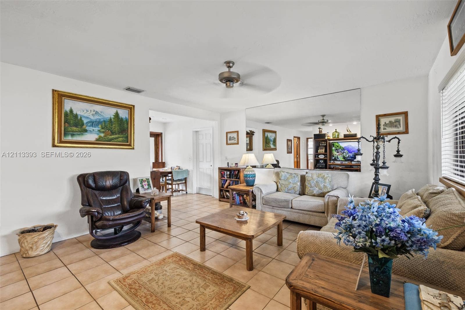 4136 SW 49th Street, Dania Beach, FL 33314 Living area featuring square tile flooring, a ceiling fan, and a large wall-mounted mirror