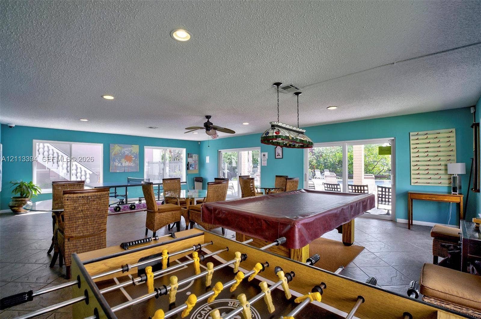 124 NE 19th Court, #108B, Wilton Manors, FL 33305 Spacious recreation room featuring neutral tile flooring, recessed lighting, ceiling fan, and sliding glass doors