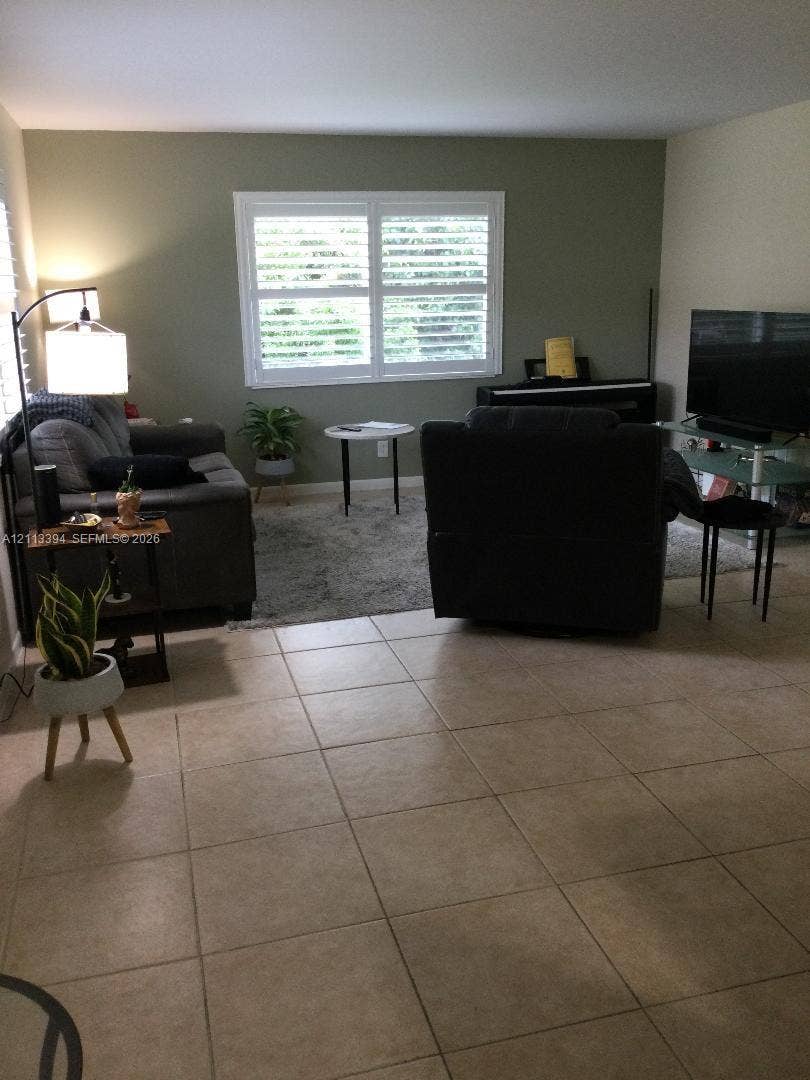 124 NE 19th Court, #108B, Wilton Manors, FL 33305 Neutral-toned tile flooring and window shutters
